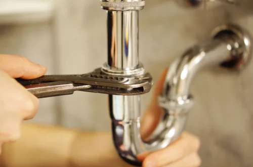 Person using a plunger to unclog a drain in a bathroom sink