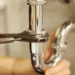 Person using a plunger to unclog a drain in a bathroom sink