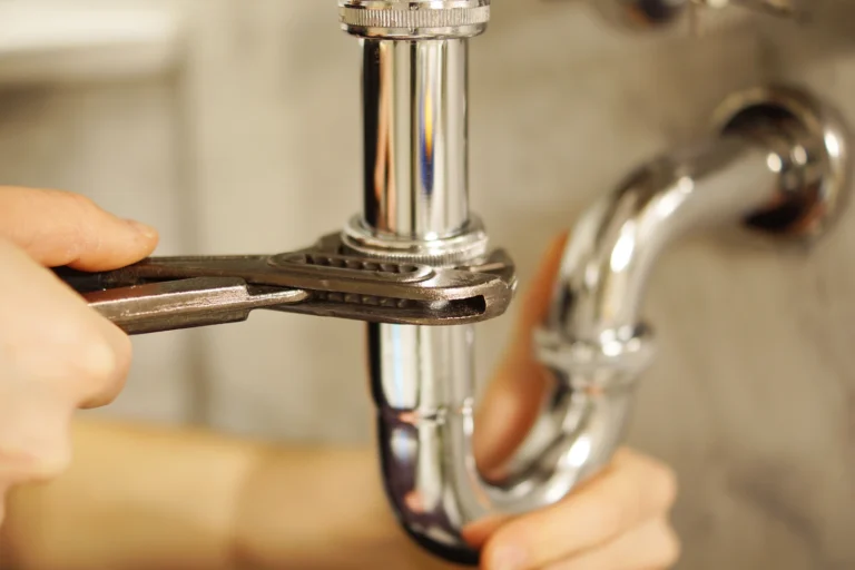 Person using a plunger to unclog a drain in a bathroom sink