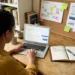 Small business owner planning blog topics while using AI for content marketing on a laptop